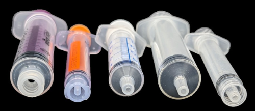 Figure 1. The two syringes on the left are ENFit (enteral) syringes equipped with tips that prevent them from attaching to a Luer connector. The syringe in the middle is an oral syringe that is difficult to attach to an IV connector. The two syringes on the right are Luer Slip and Luer Lock (parenteral) syringes made to attach to IV connectors. Photo courtesy of GEDSA. 