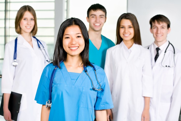 Healthcare practitioners standing in group, Three women, two men