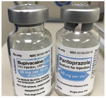 The vials have different geometric shapes on the primary display panels, but both labels use a light blue color, and both clear glass vials are the same size with aluminum ferrules, contributing to their similar appearance.